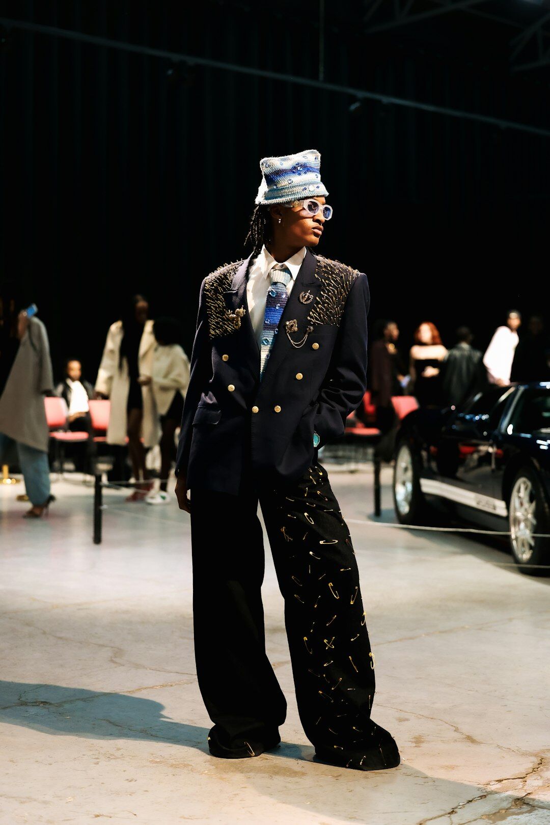 Model in a tailored navy suit backstage at a fashion show