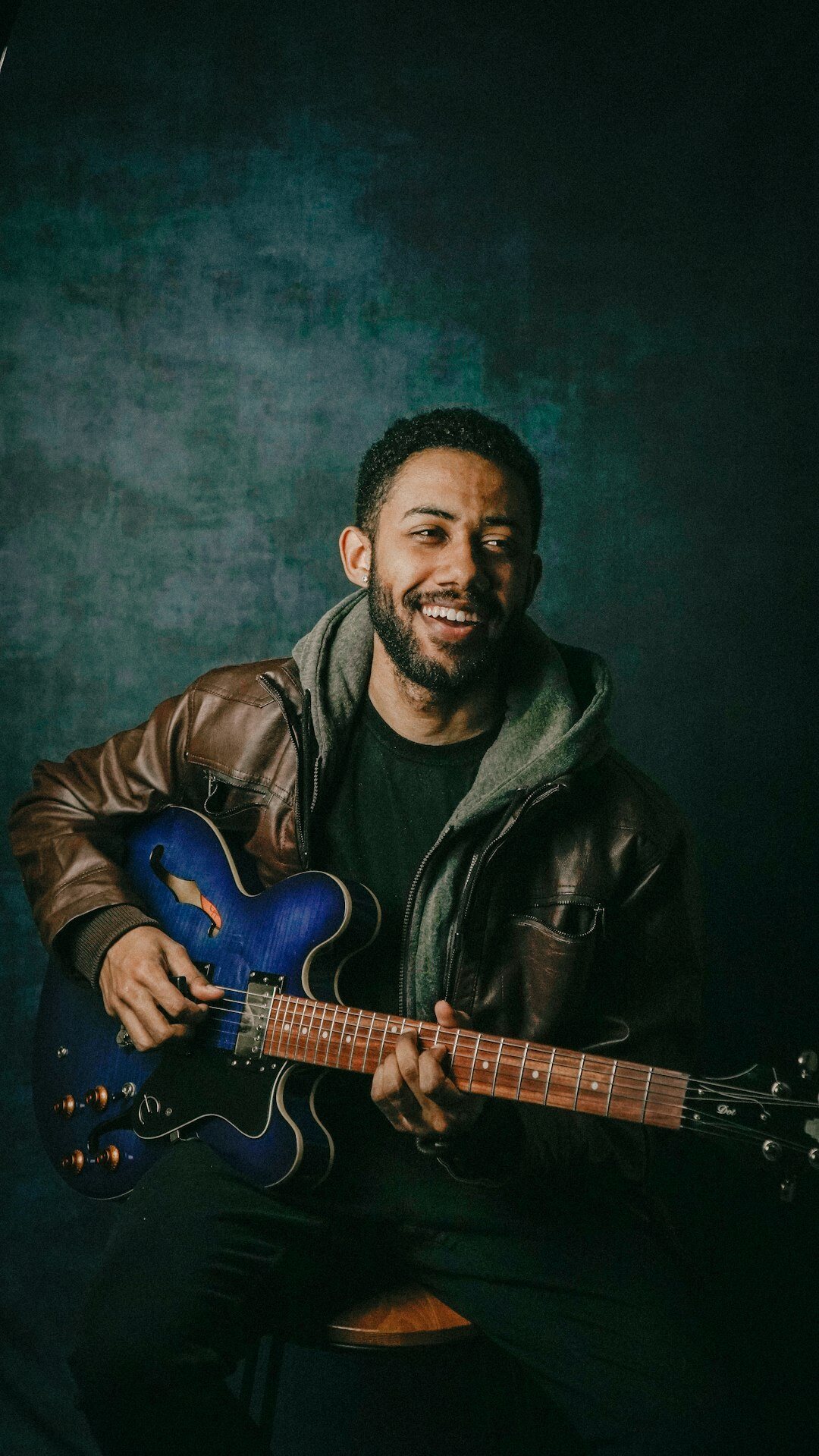 Belgian musician portrait with an acoustic guitar in a recording studio